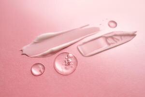 Gel, serum and a cream on a pink background. photo