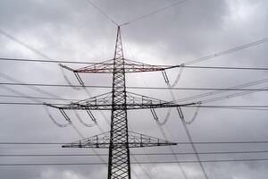 grande electricidad pilones en detalle debajo Tormentoso cielo foto