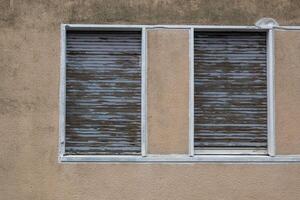 old roller shutters lowered in a window photo