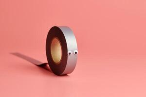 Electrical tape roll, copy space. Cute eyes, minor repairs in house concept. Minimal pink background. photo