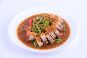 Stir-fried pork belly crisp with red curry on the white background. photo