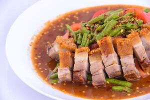 Stir-fried pork belly crisp with red curry on the white background. photo