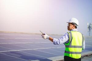 Engineer checks the electrical energy generated from solar cells. engineer working with solar cells. photo