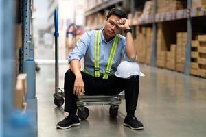 Asian warehouse worker who is unhappy after being fired from his job Unemployed people fail, hopelessness, depression. Workers are tired from work. photo