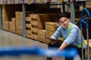 Asian warehouse worker who is tired from work. Being fired from work. Unemployed. Failed. Hopeless. Burned out at work. photo