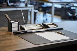 lugar de trabajo de oficina con papelería. jefe, jefe, supervisor o jefe del lugar de trabajo de la empresa en la oficina moderna. cómoda mesa de trabajo y silla de cuero para computadora. foto