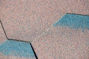 Modern roof shingles tiles, close up. Soft asphalt roof cover. New roofing construction. Easy roofing repair. photo