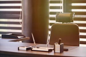 Business office workplace. Work place for chief, boss or other employees. Table and comfortable chair. Light through the half open blinds photo