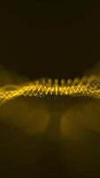 Vertical video - a gently undulating golden digital fractal light wave of glowing gold particles animation. This abstract technology motion background is HD and a seamless loop.