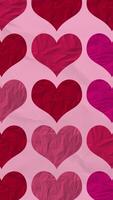 verticale video - carino San Valentino cuori modello su spiegazzato carta struttura sfondo nel rosso e rosa colore toni. Questo strutturato romantico San Valentino giorno movimento sfondo design è HD e ciclo.