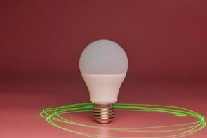 Energy saving light bulb, green laser beam around, copy space. Minimal idea concept. photo