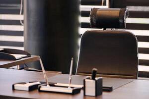 lugar de trabajo de la oficina de negocios. lugar de trabajo para jefe, jefe u otros empleados. mesa y silla cómoda. luz a través de las persianas entreabiertas foto