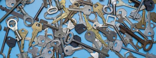 Keys set on blue background. Door lock keys and safes for property security and house protection. Different antique and new types of keys. photo