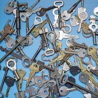 Keys set on blue background. Door lock keys and safes for property security and house protection. Different antique and new types of keys. photo