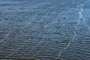 contaminación de la línea de espuma en el río. emisiones de aceite de fábrica, contaminación ambiental. río azul profundo con fuerte corriente. foto