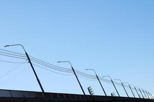 Lampposts on bridge. Road light poles, copy space. LED light post for street lighting at night. photo