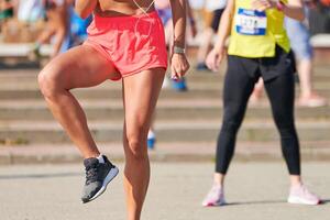 Young woman warming up before running marathon photo