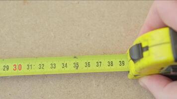 Hand of master or engineer who makes measurements using tape measure. Close-up light movement. video