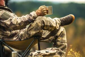 A Hunter Relaxing During Hunting Trip Drinking Coffee Close Up photo