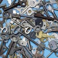 Keys set on blue background. Door lock keys and safes for property security and house protection. Different antique and new types of keys. photo