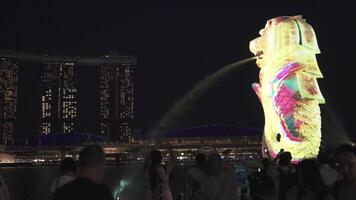 Singapur, Singapur, 2021 - el merlion iluminado a noche - un mítico criatura con un leon cabeza y el cuerpo de un pescado ese usado como mascota video