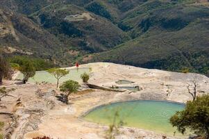 Girl on top of a white mountain with blue lakes and springs in Mexico hierve del agua photo