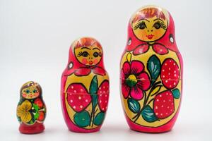 ruso matrioska anidamiento muñecas, pintado a mano con gente motivos, rojo floral decoración, cultural artesanía, ornamental piezas, símbolo de ruso herencia, de madera juguetes blanco antecedentes foto