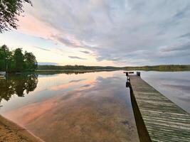 Wooden jetty jutting into a Swedish lake. Nature shot from the Scandinavian photo