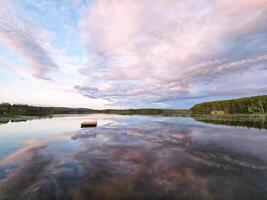 Swimming island in Sweden on a lake at sunset. Clouds reflected in the water. photo