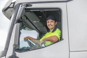 Smiling male driver looking through window of truck photo