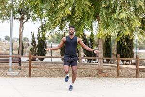 Strong sportsman exercising with skipping rope photo