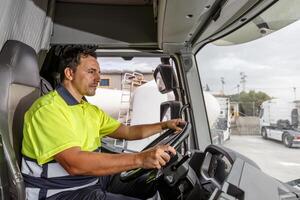 Serious male driver driving tanker truck in compound photo