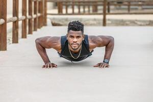 Muscular black athlete doing push ups photo