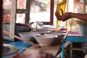 Preparing chicken noodles. View of a meatball chicken noodle seller who is making chicken noodles for the buyer. photo