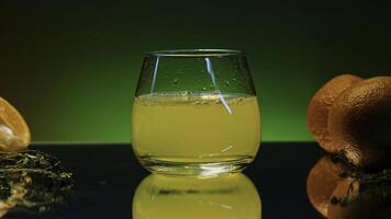 Drop falling into orange juice. Stock clip. Orange juice with alcohol in glass on isolated background. Alcoholic drink with juice and oranges in bar photo