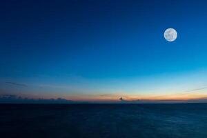 Fullmoon on sky at the lake in the twilight. photo