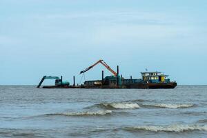 Machines are dredging sand in the sea. photo