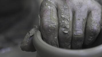 Close up of hands of a potter while creating a clay jar, ceramics production concept. Stock footage. The sculptor male hands in the workshop making a vase or jar. photo