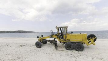 parte superior ver de tractor en playa. acción. excavadora borra blanco playa por mar. excavadora borra escombros o niveles playa a mar foto