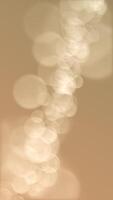 Vertical video - defocused golden bokeh lights background. This elegant motion background animation with lens blur bokeh sphere particles is full HD and a seamless loop.