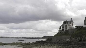 panorámico aéreo ver de el cabañas de blanco y rojo ladrillos situado en el repisa por el mar costa. acción. lado ver de el ladrillo casas cerca el costa línea en nublado cielo antecedentes. foto