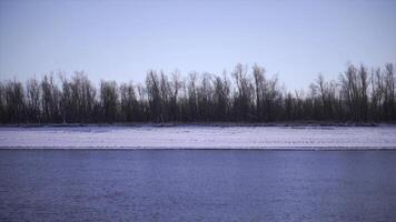 Shoreline of river with ice in spring. Clip. Beautiful beach with water and ice on winter day. River with ice near shore on sunny winter day photo