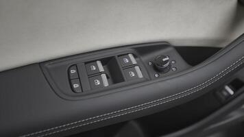 Buttons on handle of car in cabin. Action. Modern leather interior of car. New control buttons in car interior photo