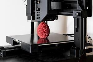 cerca arriba de un 3d impresora impresión un rojo poligonal huevo foto