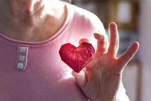 Woman hands holding red 3d printed heart. Ideal for diverse concept, love and health, gratitude and charity either technology photo