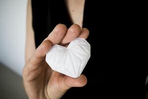 Woman holding white 3d printed heart. Ideal for diverse concept, love and health, gratitude and charity either technology photo