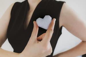 Woman holding white 3d printed heart. Ideal for diverse concept, love and health, gratitude and charity either technology photo