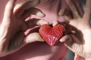 Woman hands holding red 3d printed heart. Ideal for diverse concept, love and health, gratitude and charity either technology photo