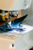 Man using a sewing machine with a blue garment, for repair work, customization, creation, upcycling photo