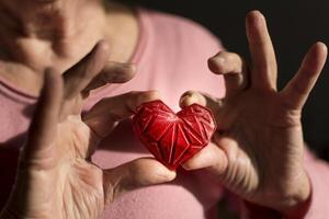 Woman hands holding red 3d printed heart. Ideal for diverse concept, love and health, gratitude and charity either technology photo